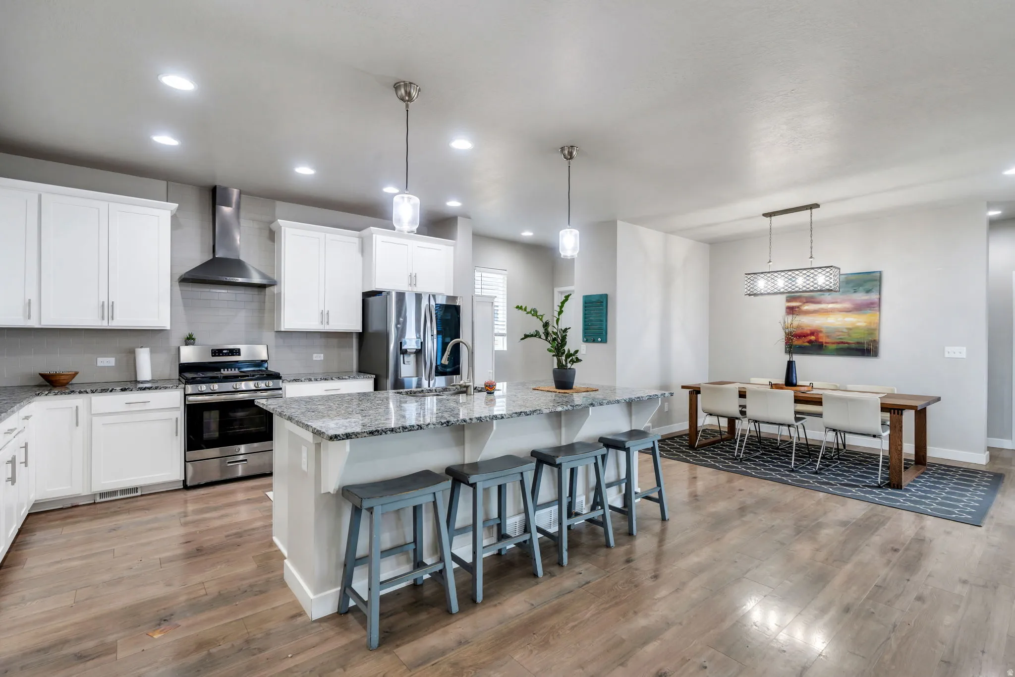 Designed with both beauty and functionality in mind, this gourmet kitchen offers a large granite island, elegant vent hood, generous workspace, and an open layout that keeps everyone connected
