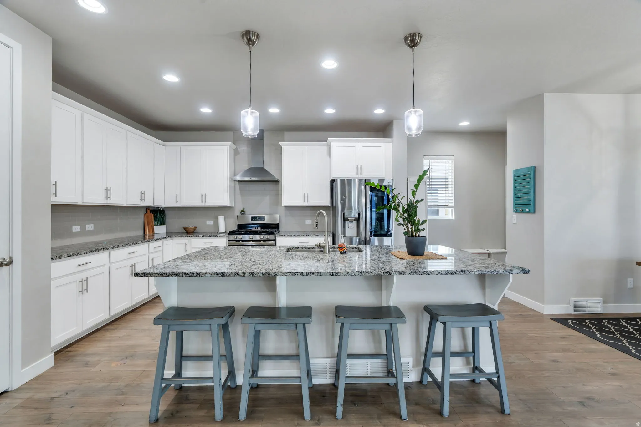 The heart of the home is this beautifully appointed gourmet kitchen, featuring a striking vent hood, abundant cabinetry, and a spacious granite island that serves as the perfect gathering place for meal preparation, casual dining, and conversation.
