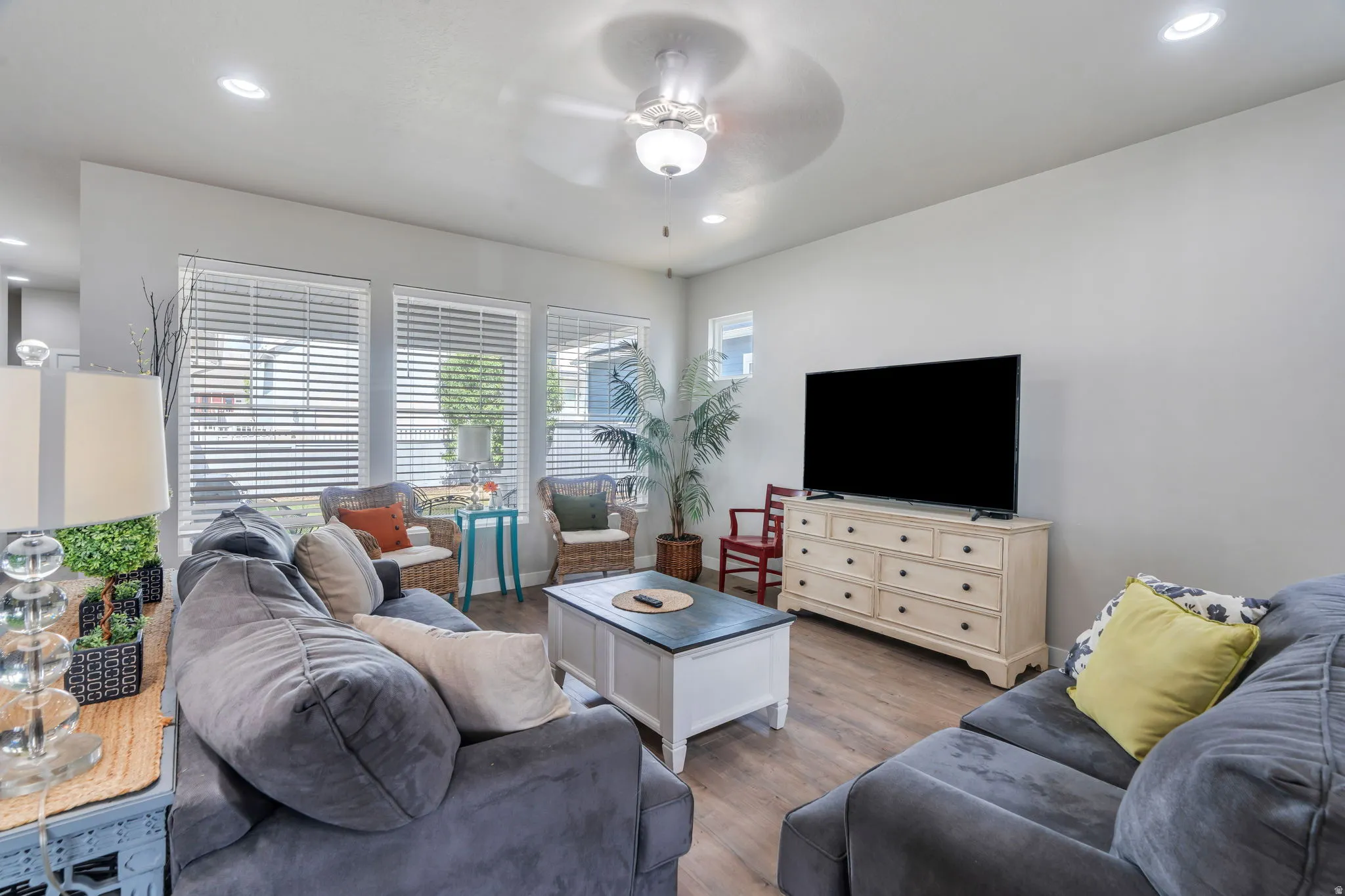 Open-concept living area featuring wood-finish flooring, recessed lighting, and a ceiling fan