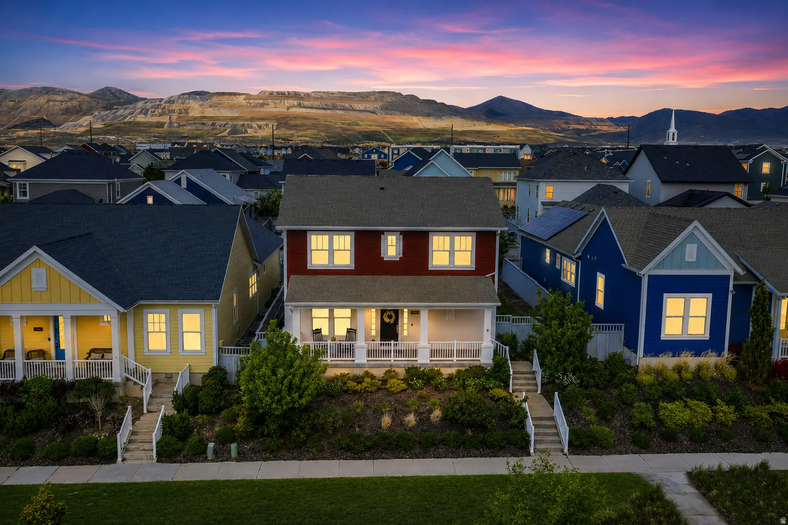 Two-story residence featuring a red exterior, white trim, and a covered front porch with white railings