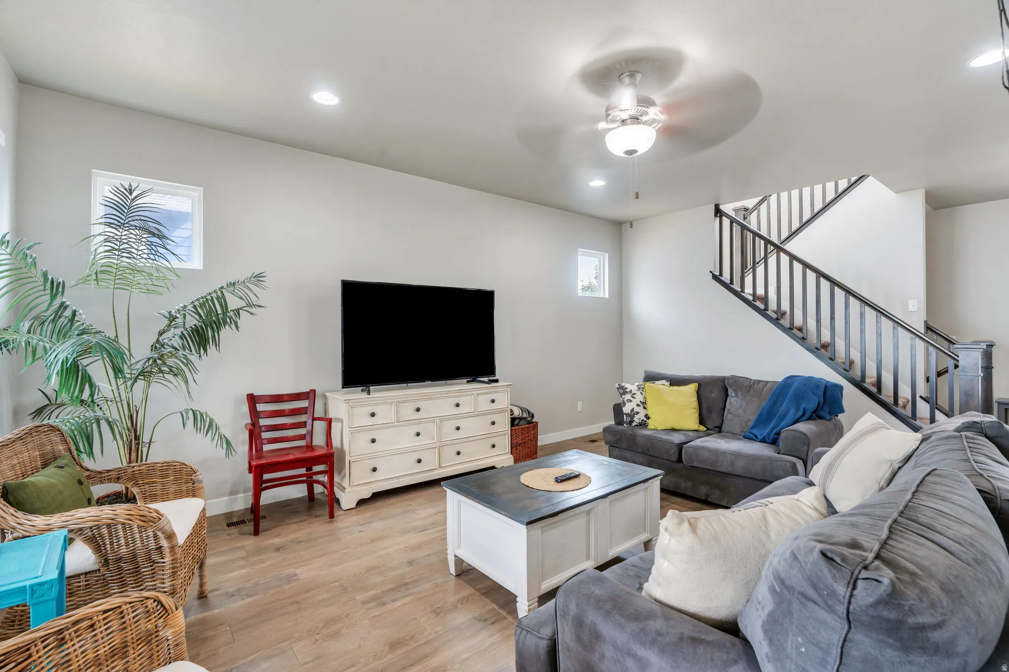 Spacious living area featuring wood-finish flooring, recessed lighting, and a ceiling fan