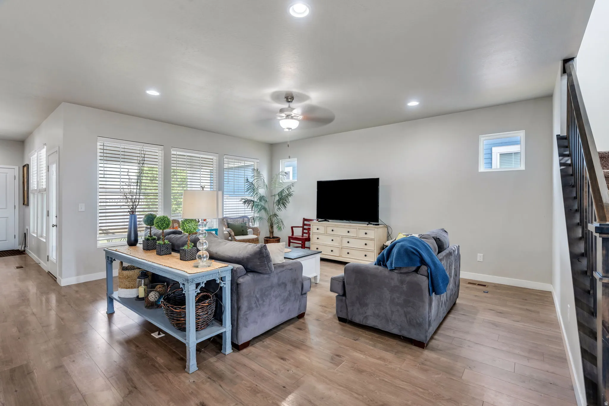 Spacious living area featuring wood-finish flooring, recessed lighting, and a ceiling fan