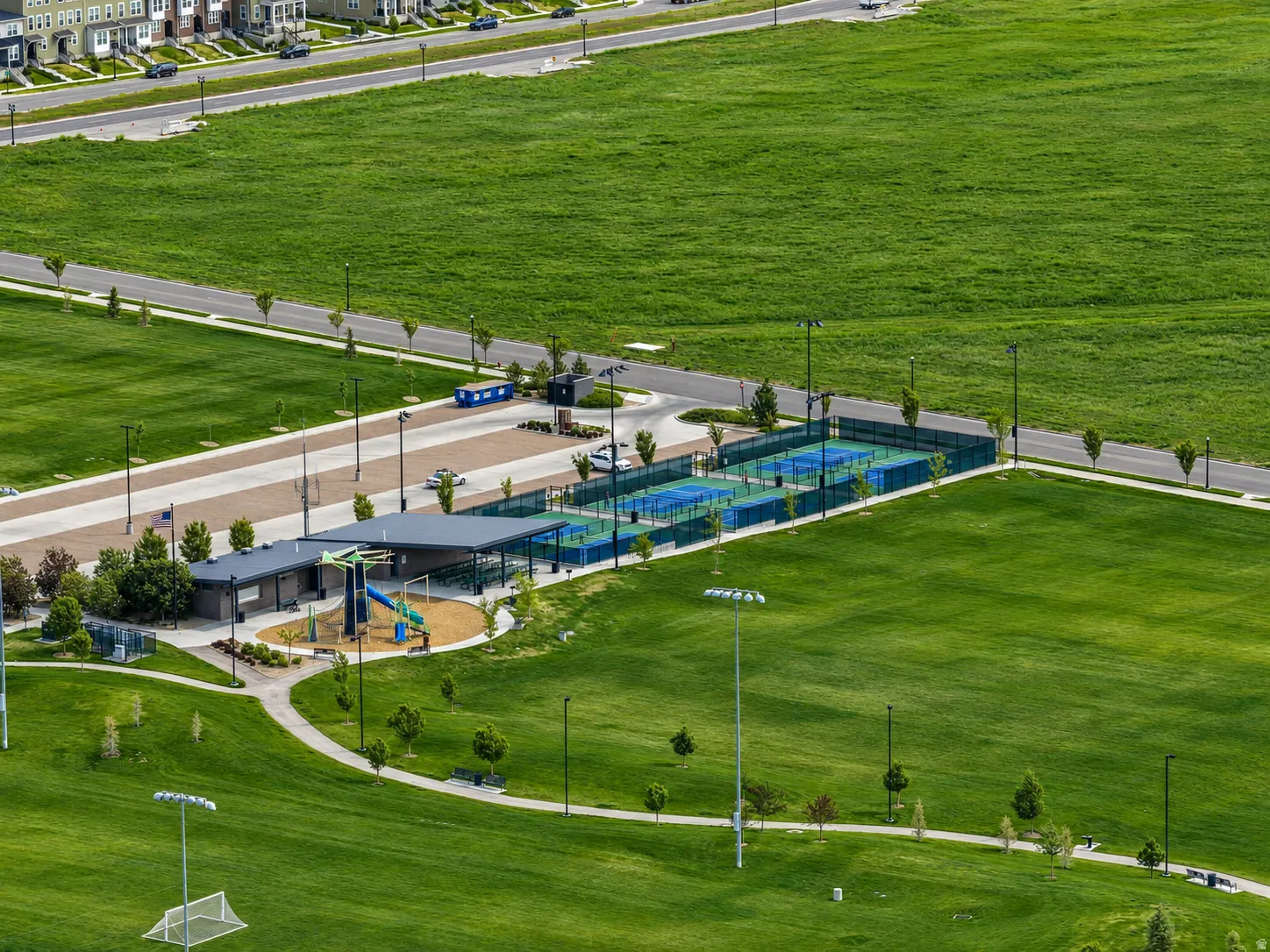 Community recreation area nearby featuring multiple pickleball courts, a covered pavilion, and a playground structure