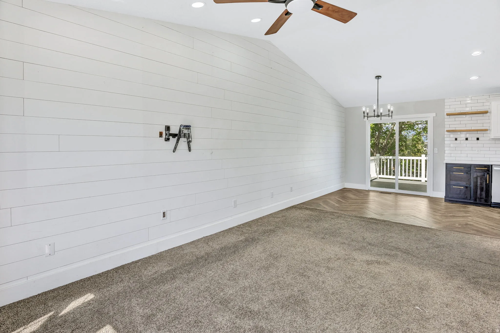 Vaulted ceiling with wood-finish ceiling fan and recessed lighting