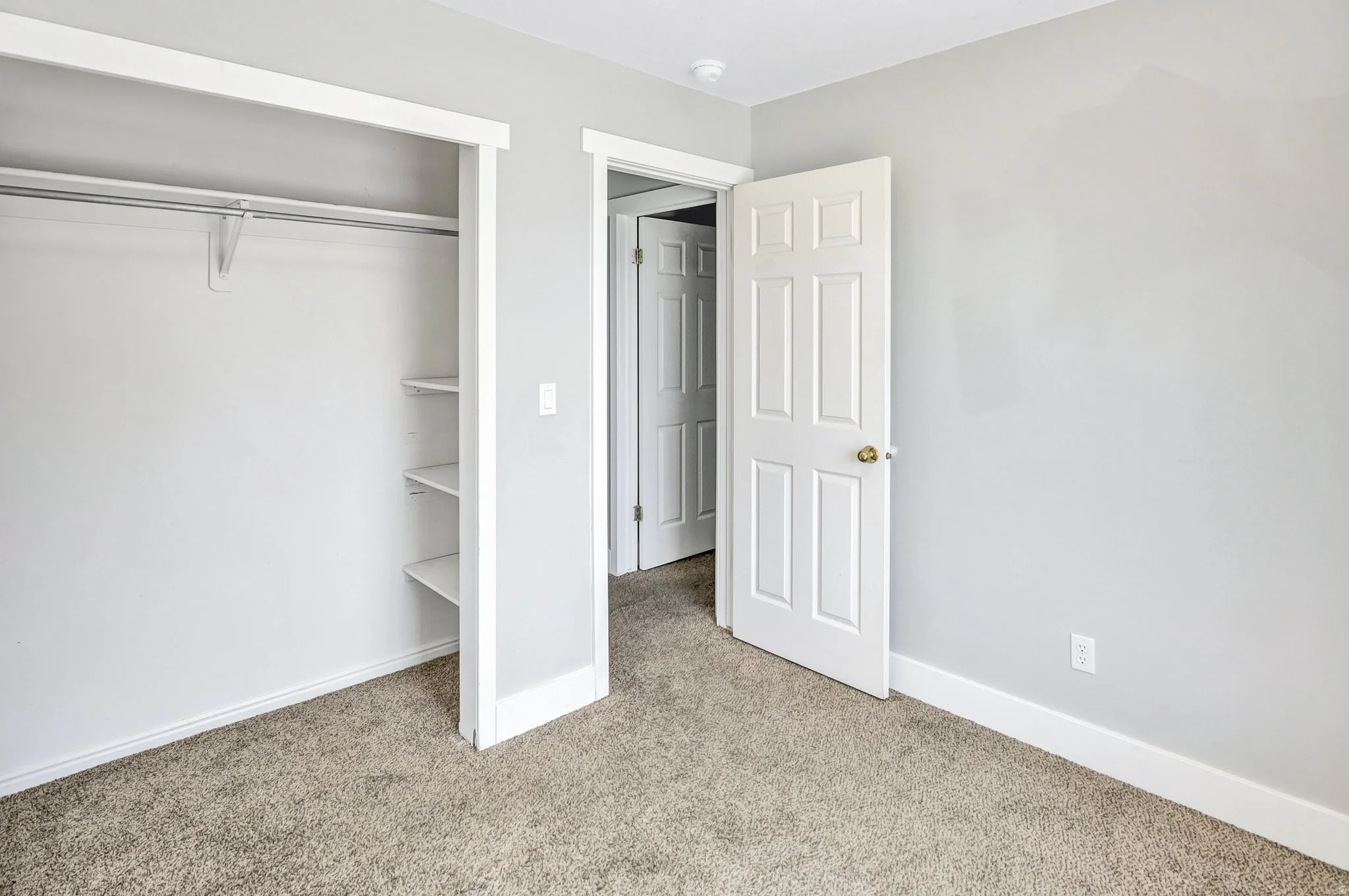 Room featuring light gray painted walls and neutral-toned carpet flooring