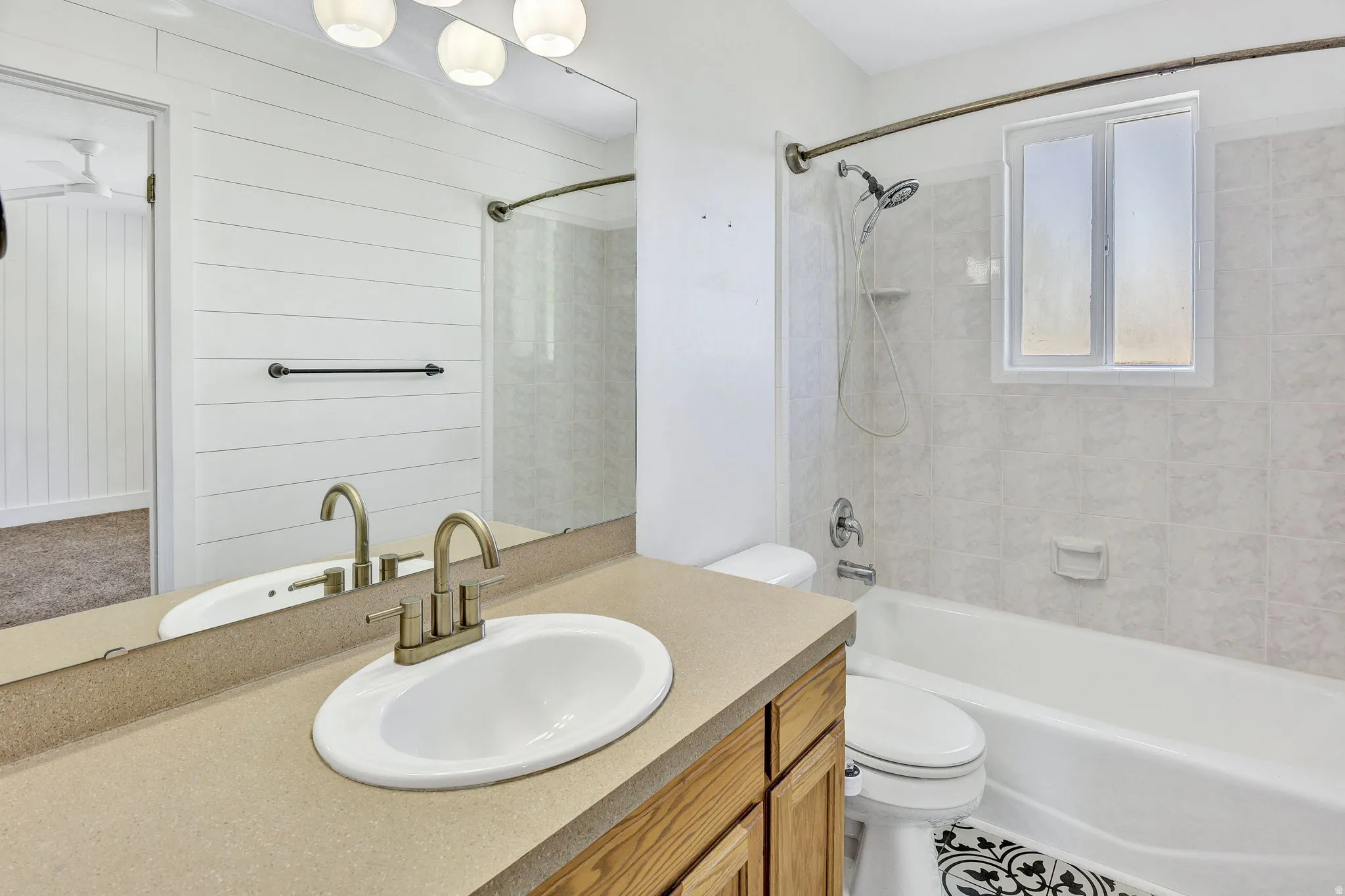 Bathroom featuring a single vanity with a neutral-toned countertop and wood-finish cabinetry