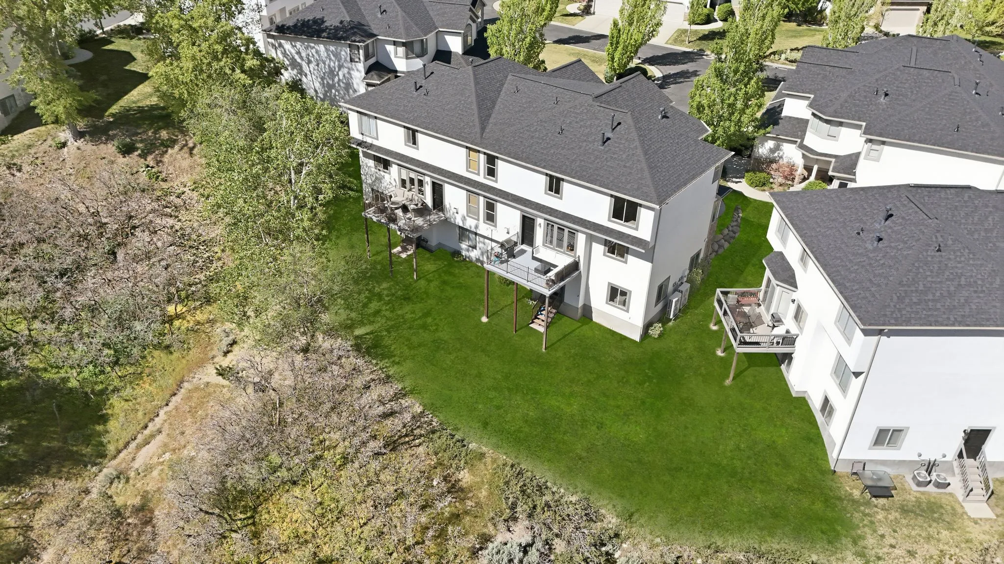 Two-story residence featuring white siding and a dark shingle roof