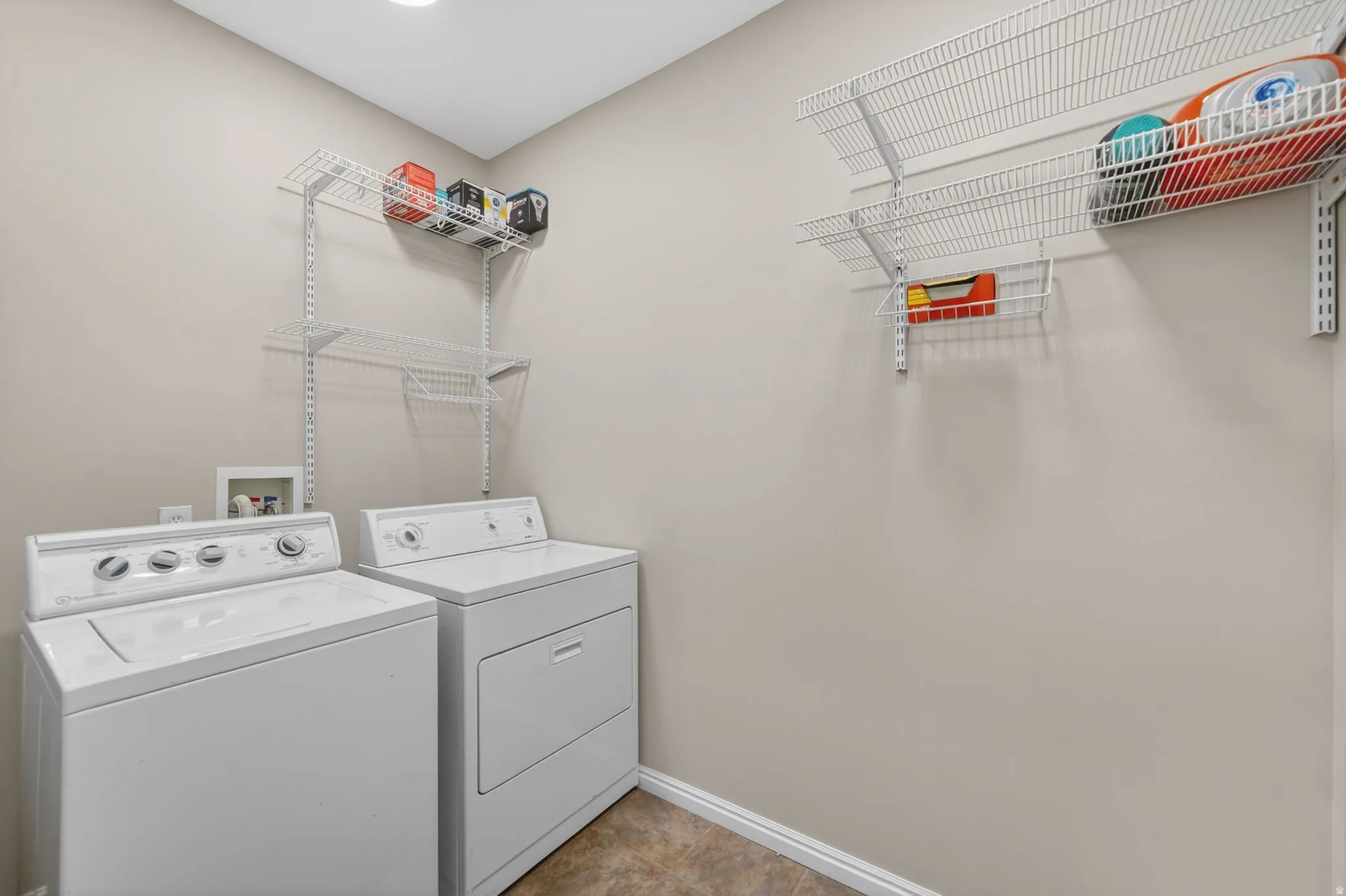 Dedicated laundry area featuring a top-load washer and front-load dryer