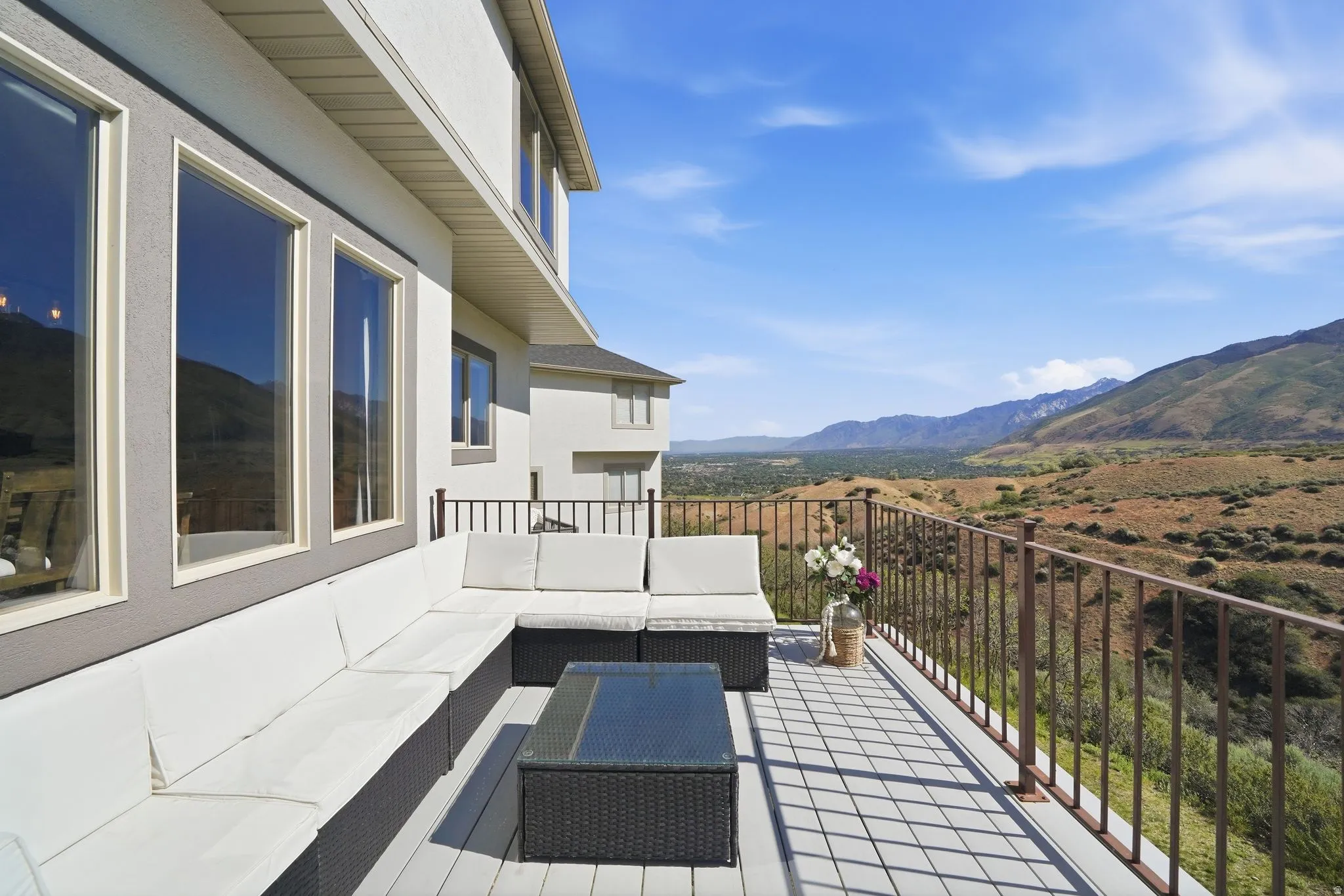 Spacious outdoor deck featuring a patterned tile surface and a metal railing