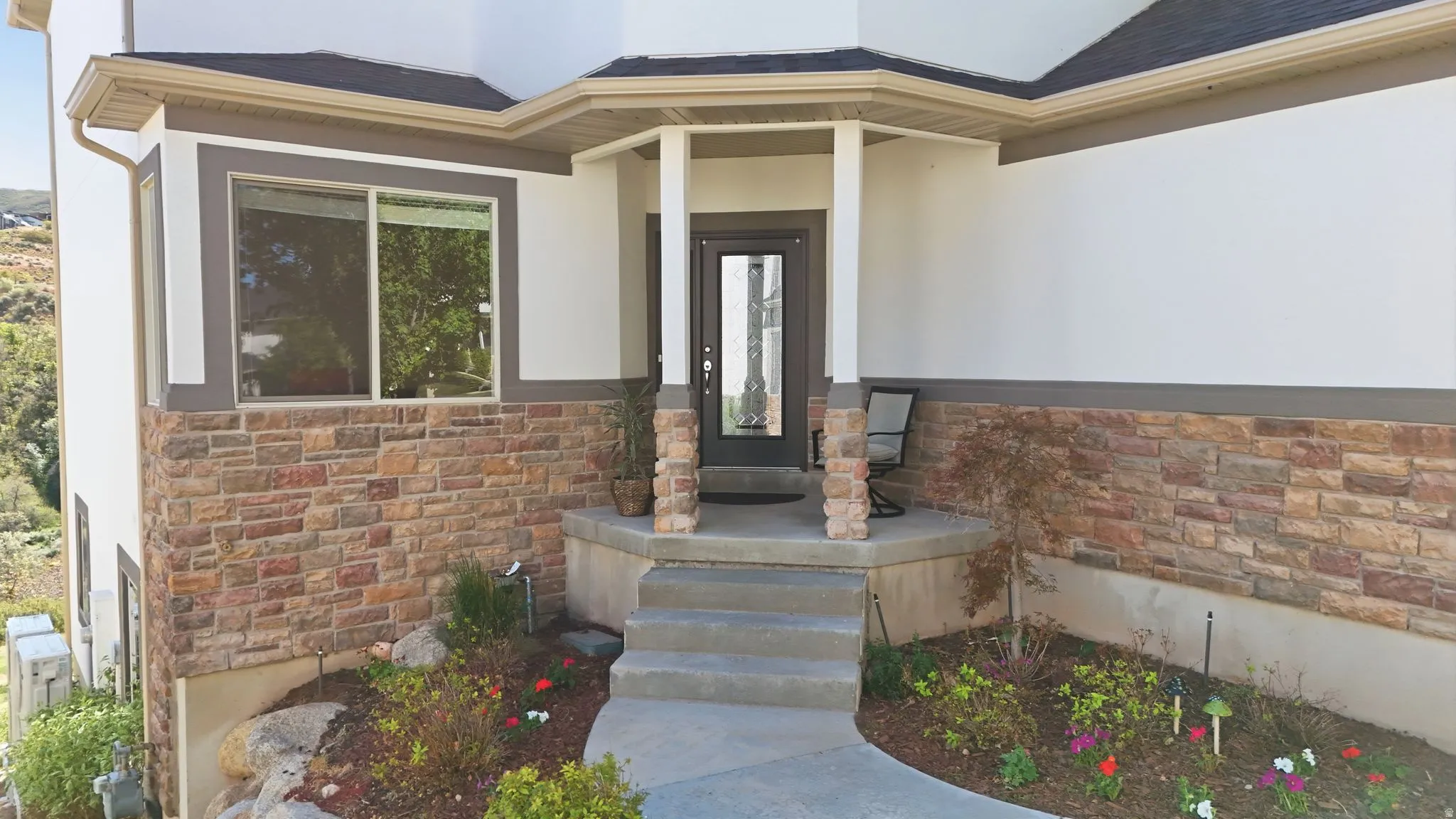 Architectural facade featuring a stone veneer base and smooth white siding