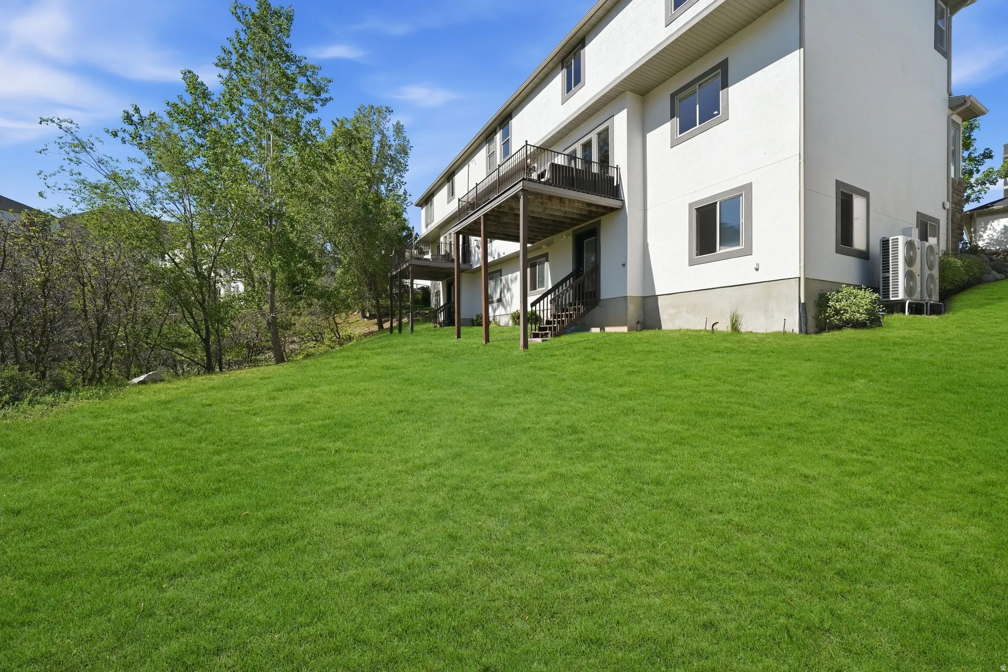 Expansive green lawn with mature trees bordering the property
