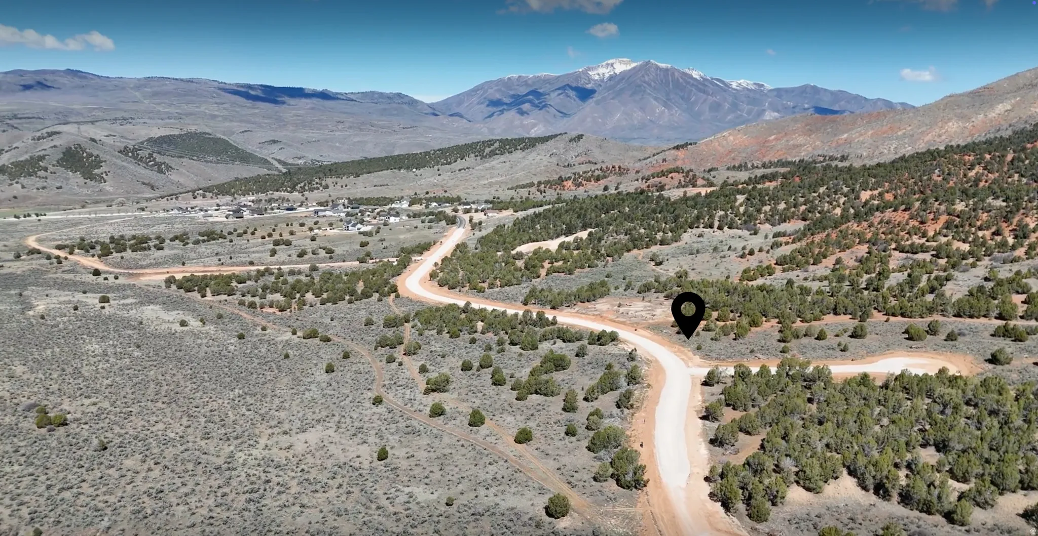 Expansive undeveloped land featuring diverse natural vegetation and a winding unpaved road