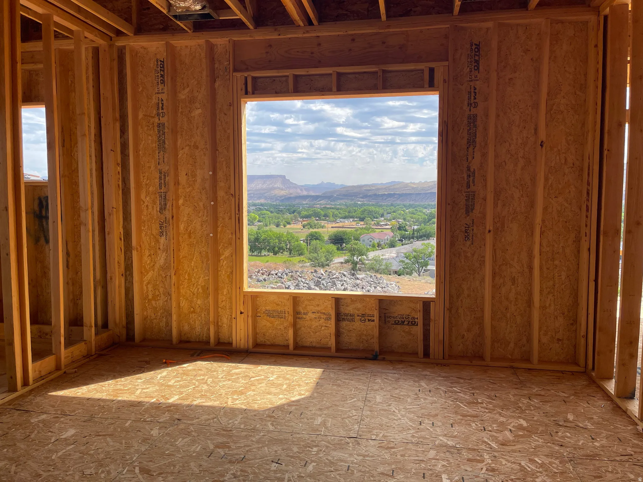 Framed interior room with expansive window opening showcasing distant mountains and surrounding greenery
