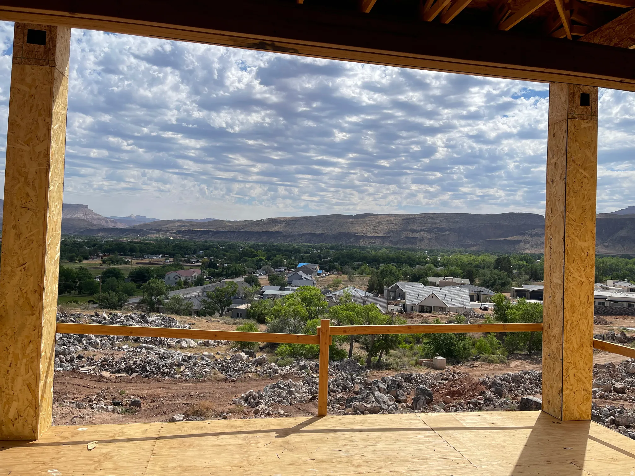 Expansive outdoor space featuring open framing, a partial wooden railing, and a durable OSB subfloor