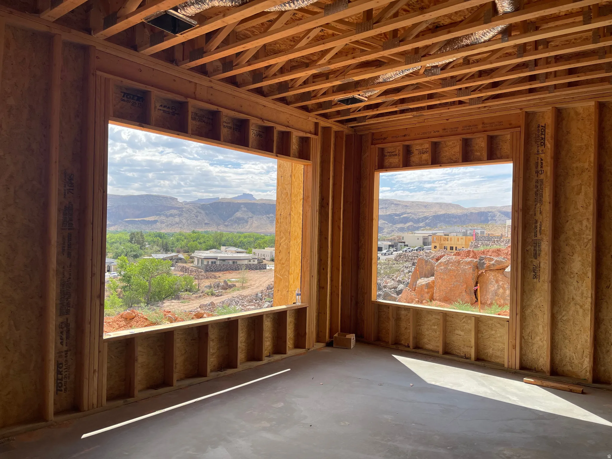 Open framing featuring two large window openings showcasing distant mountains and verdant trees