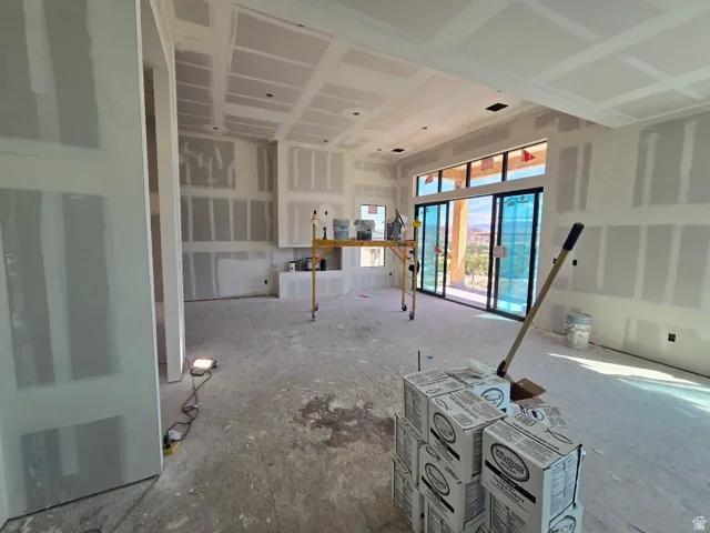 Spacious interior with high ceilings, multiple drywall-finished walls, and large sliding glass doors