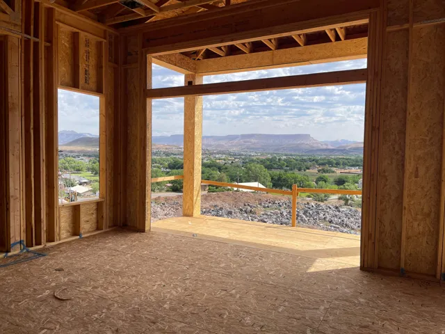 Expansive outdoor living area, showcasing a panoramic mountain and valley backdrop, with a generous window opening and natural wood framing
