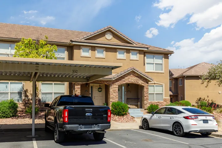 Multi-story stucco exterior with stone accents and a covered entry