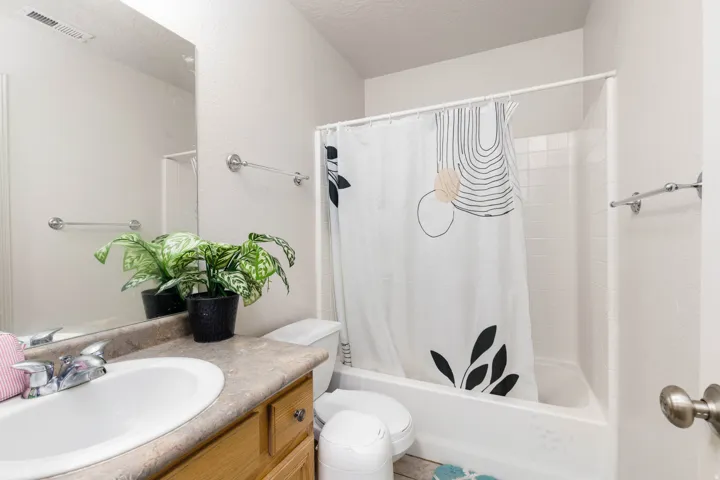 Bathroom featuring a white porcelain sink, laminate countertop, and wood-finish cabinetry