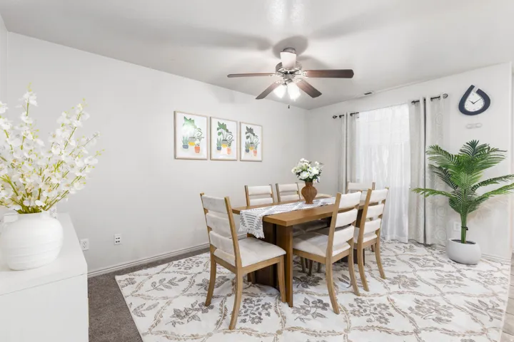 Spacious room featuring light-toned walls, a ceiling fan, and recessed lighting
