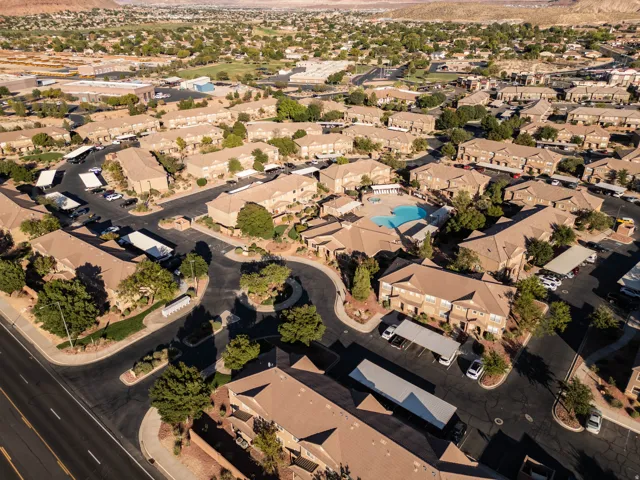 Expansive community featuring multiple residential buildings, a central swimming pool, and dedicated covered parking areas