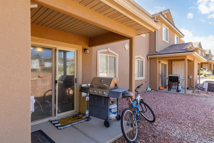 Covered patio area featuring a concrete slab and stucco exterior