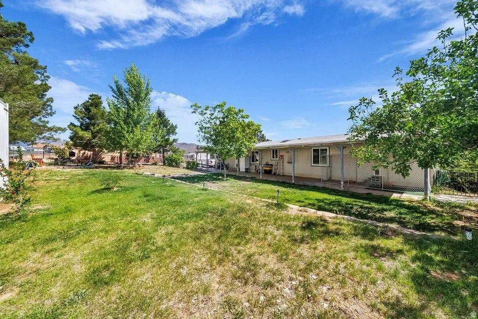 Spacious backyard featuring a sloped lawn and mature trees