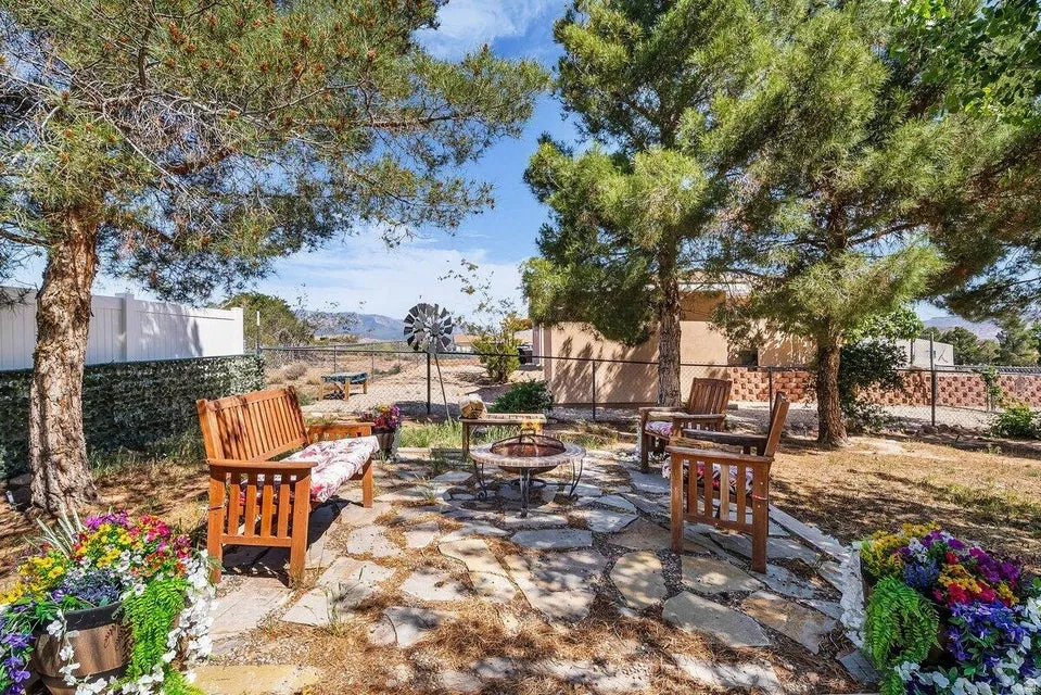 Backyard featuring a flagstone patio, fire pit, and mature trees