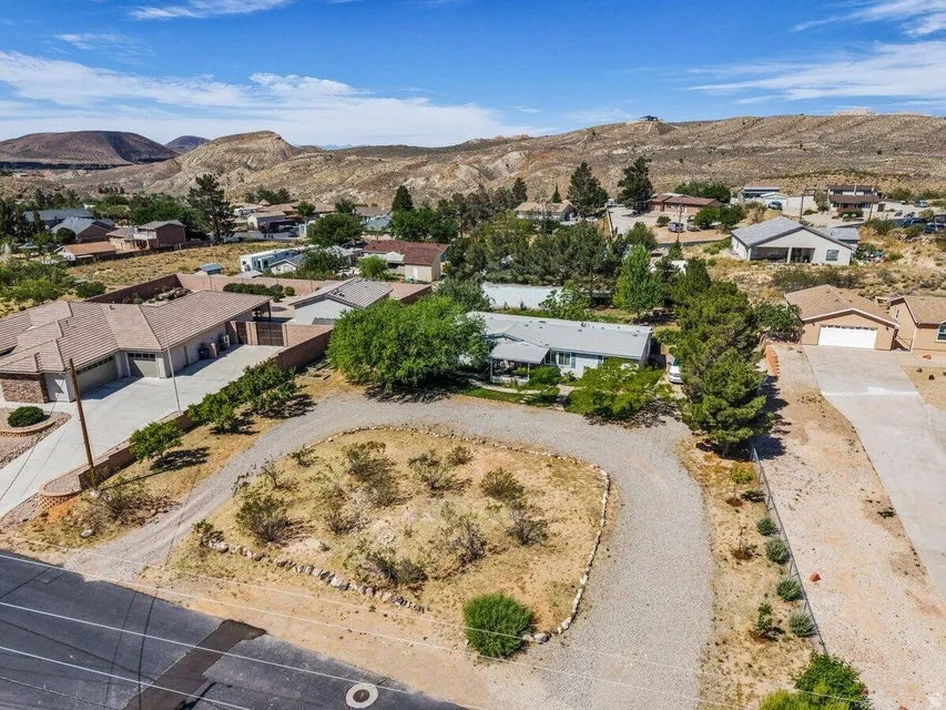Aerial perspective featuring a property with a gravel driveway and surrounding arid landscaping