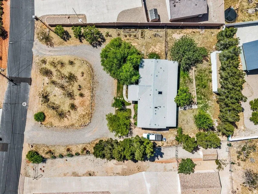 Overhead perspective of a property featuring a central residence with a light-colored roof