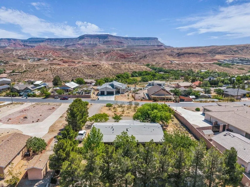 Aerial perspective showcasing a residential property with a gray roof and surrounding mature trees