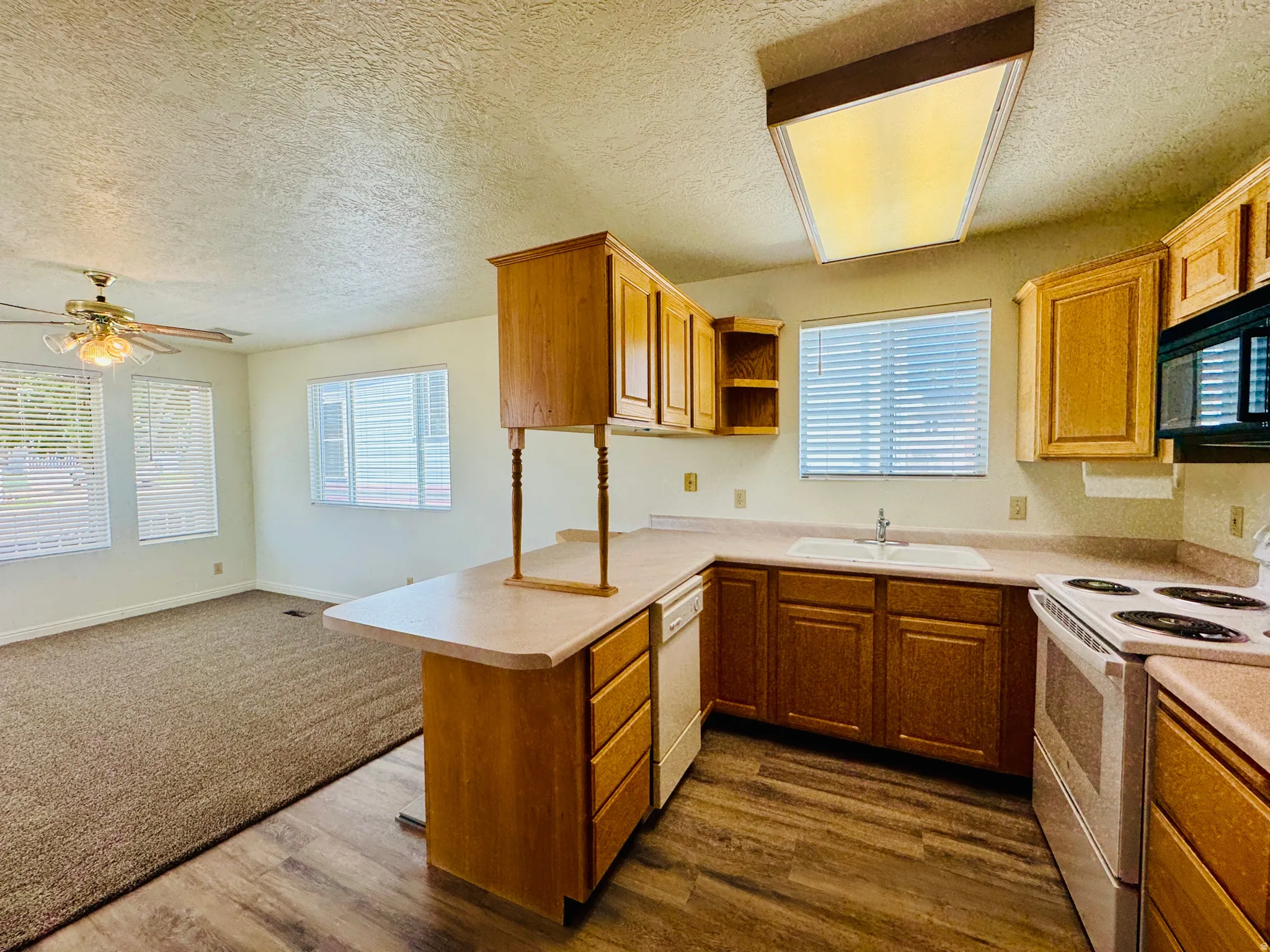 Kitchen with wood-finish flooring and L-shaped laminate countertops
