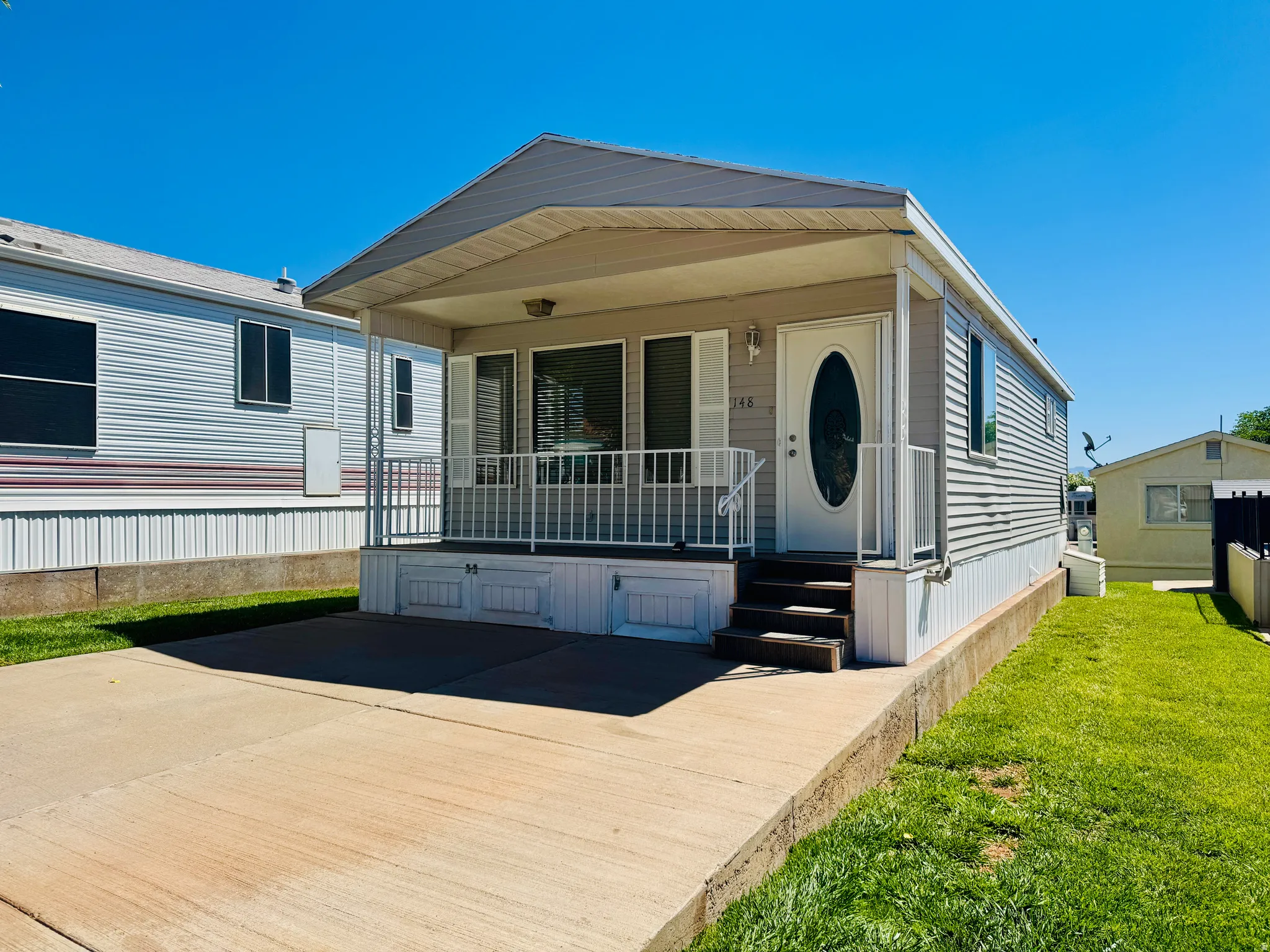 Covered front porch with white railings and three steps