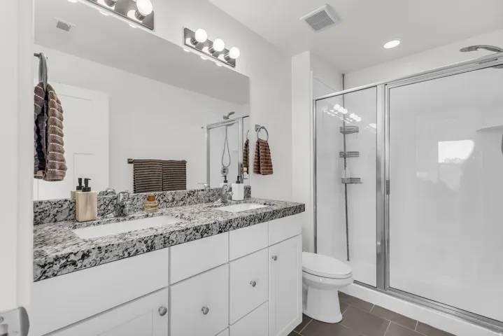 Dual vanity granite countertop and large walk in shower.