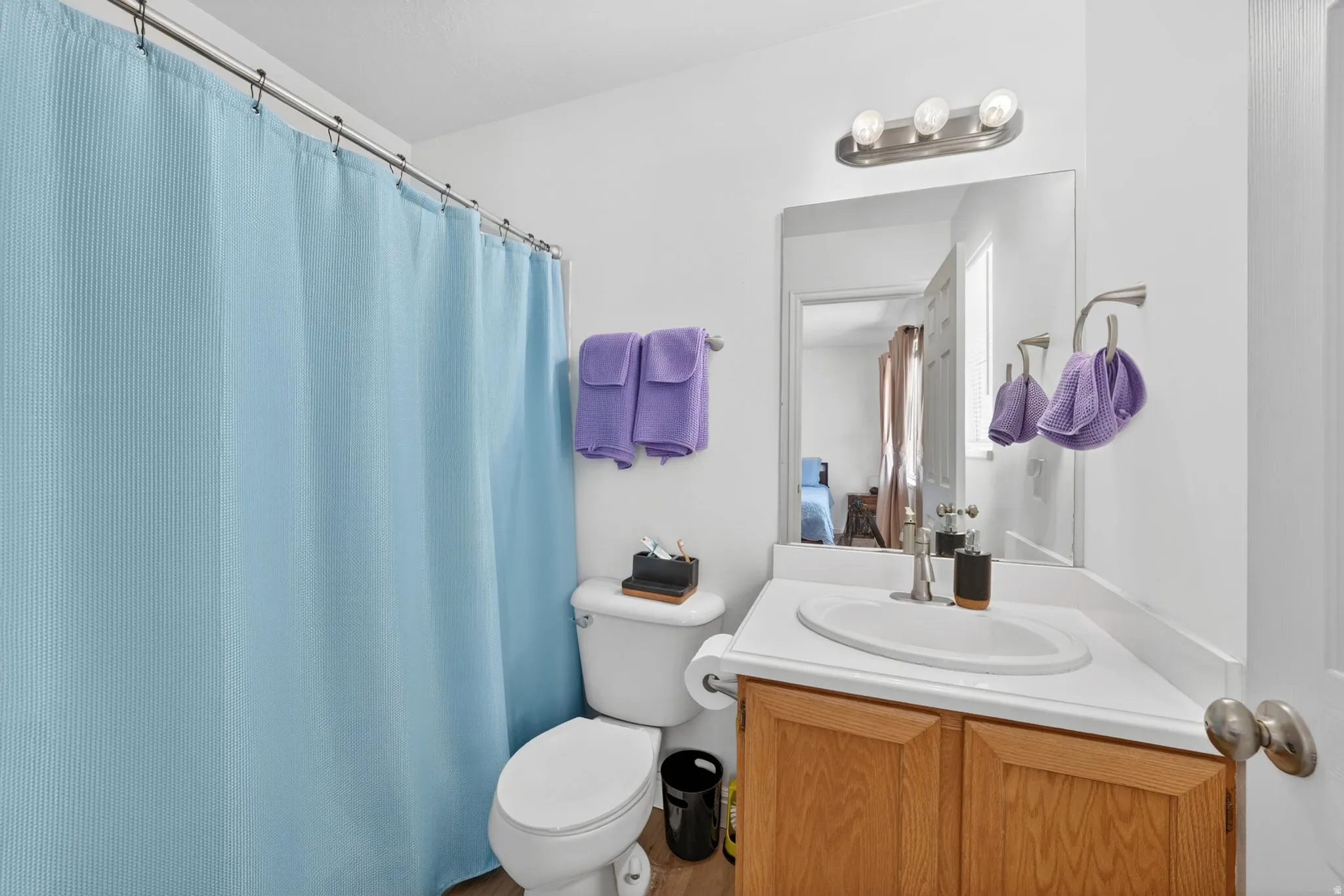 Full bathroom featuring a single-sink vanity with wood-finish cabinetry, a white countertop, and an integrated basin