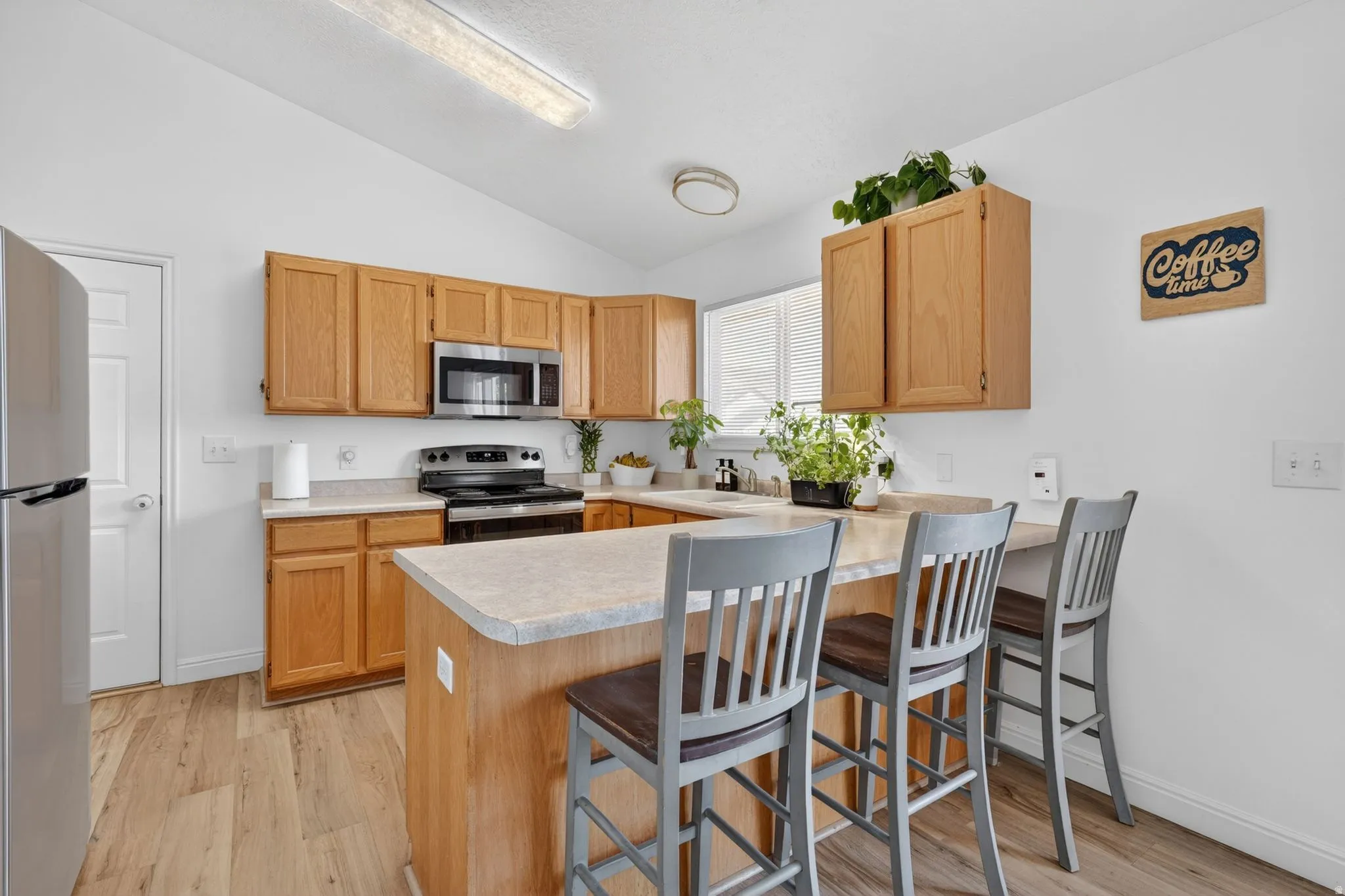 Kitchen featuring wood-finish cabinetry and light countertops