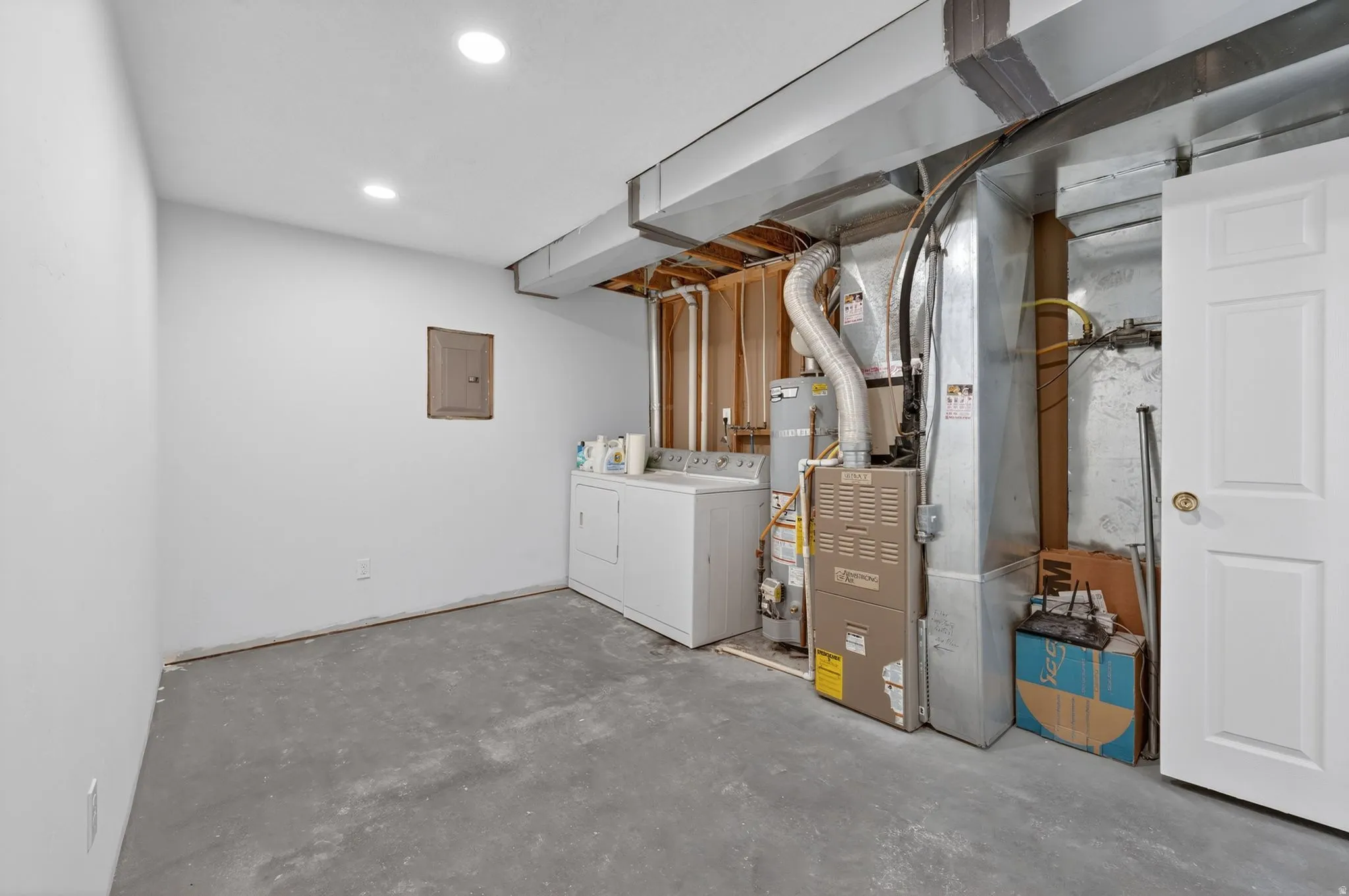 Unfinished basement area featuring a concrete floor, recessed ceiling lights, and exposed ductwork
