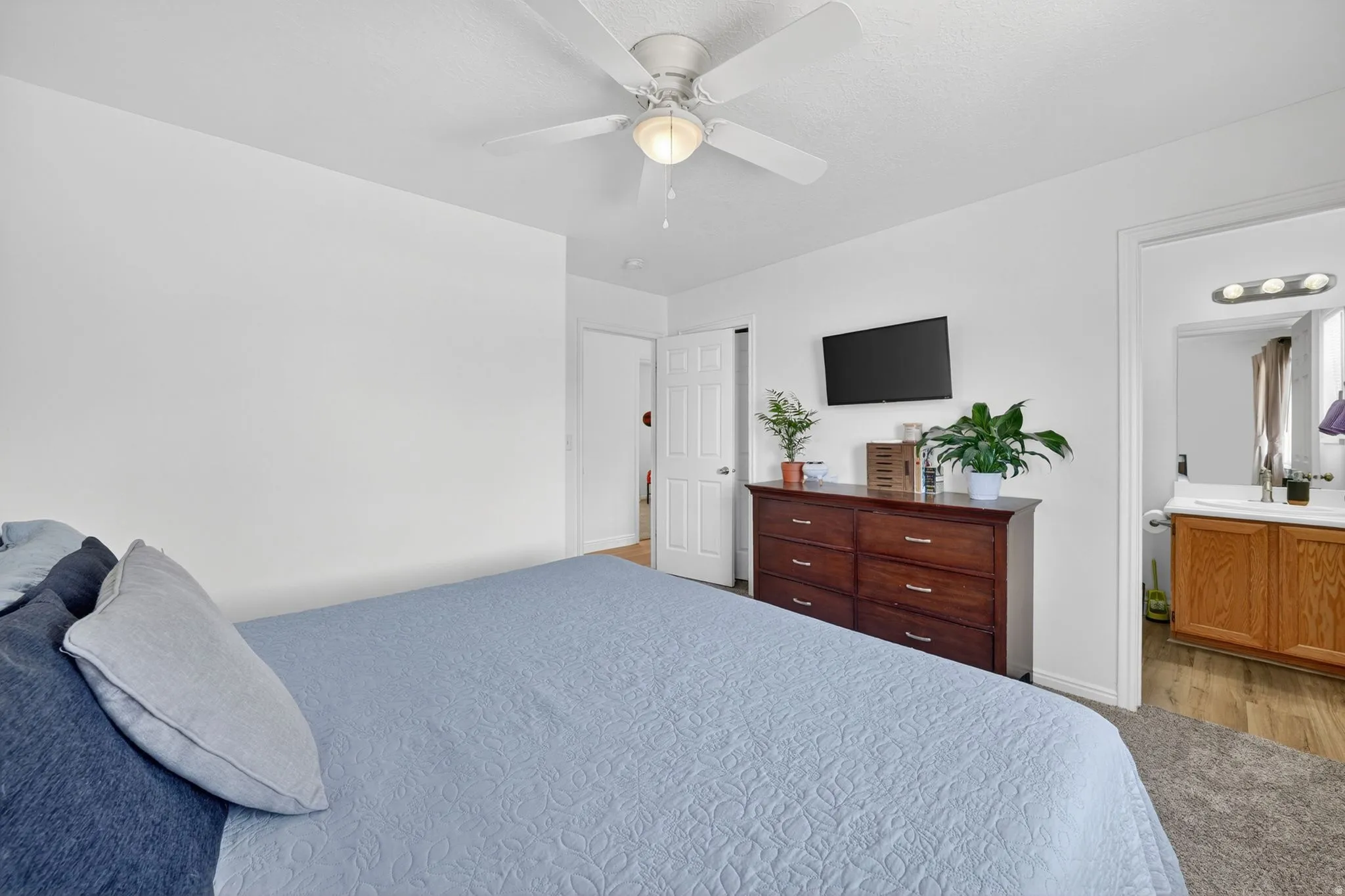Bedroom with a ceiling fan, light-toned walls, and carpet flooring
