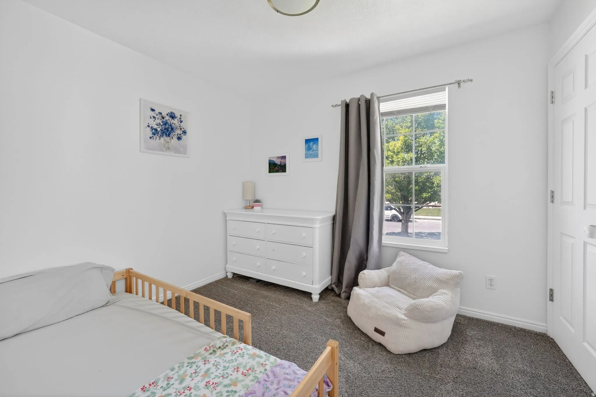Carpeted room featuring a double-paned window, white trim, and a white paneled door