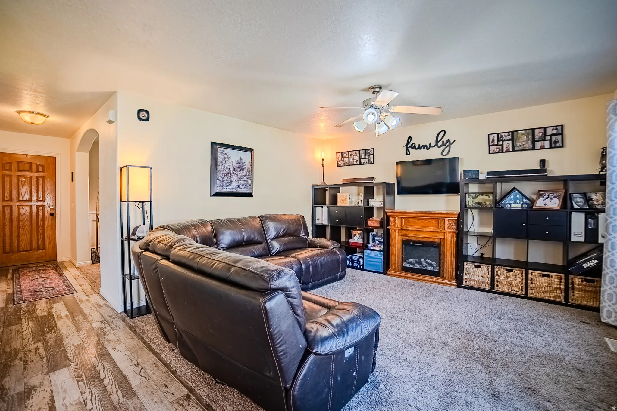 Spacious living area featuring a built-in electric fireplace with a wood-finish mantel, ceiling fan, and recessed lighting