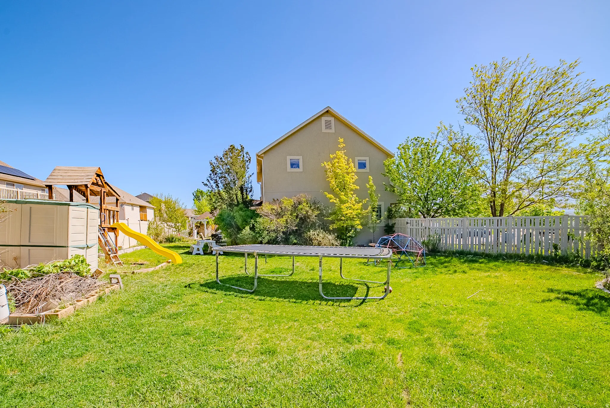 Expansive green lawn with a white picket fence enclosing the perimeter