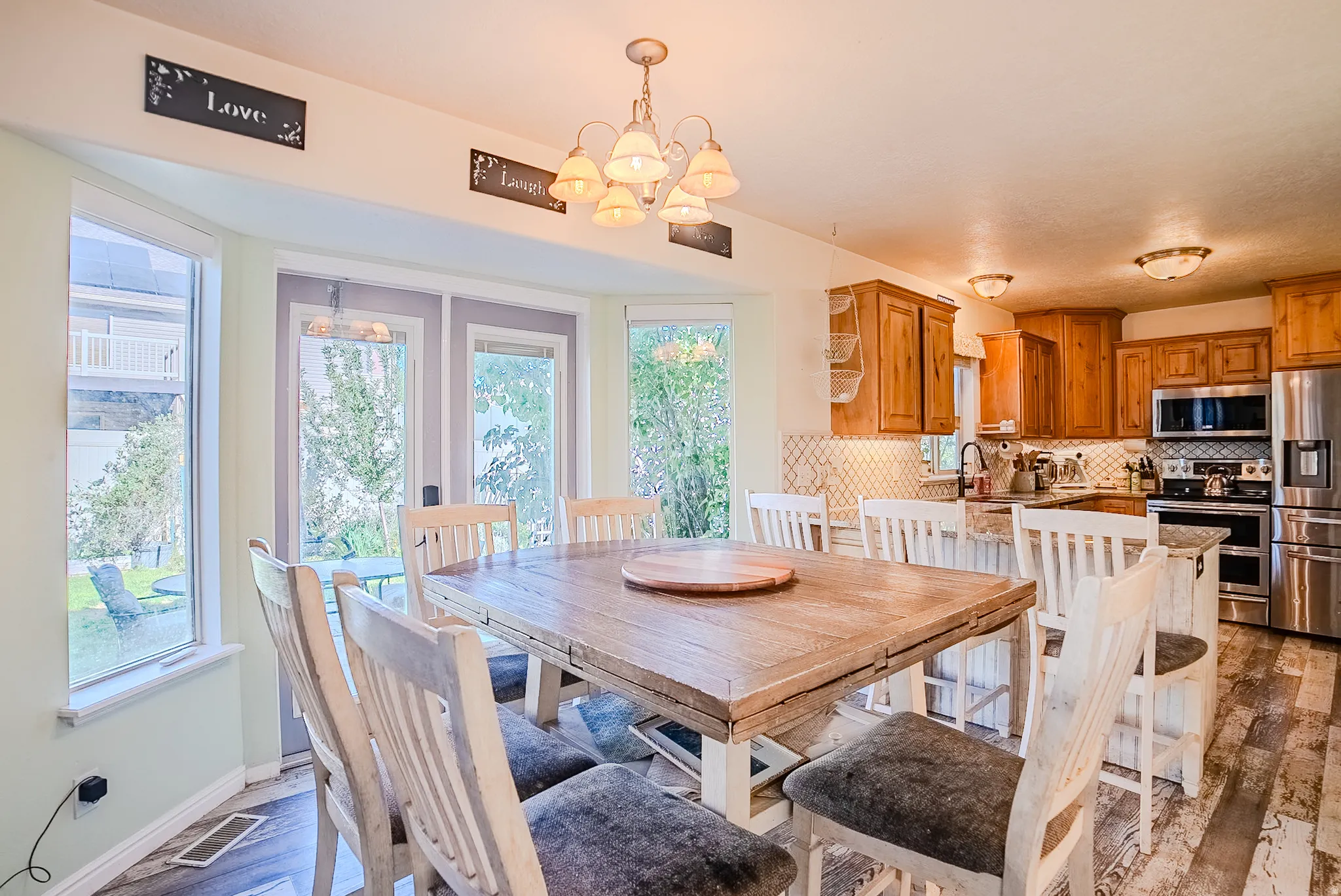 Dining area with a large wood-finish table and bay windows