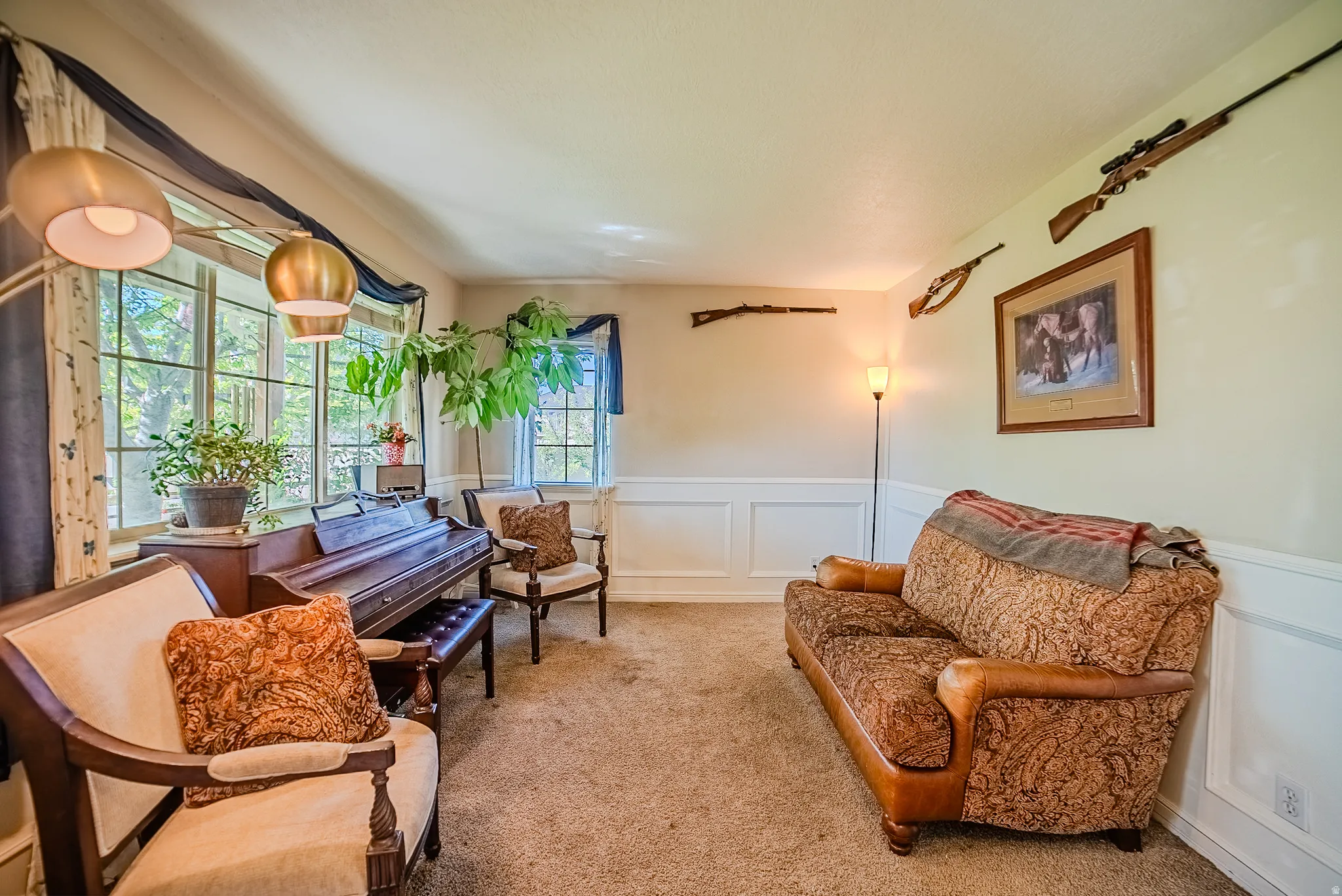 Spacious room featuring multiple windows, wainscoting, and carpet flooring