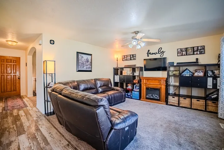Spacious living area featuring a built-in electric fireplace with a wood-finish mantel, ceiling fan, and recessed lighting