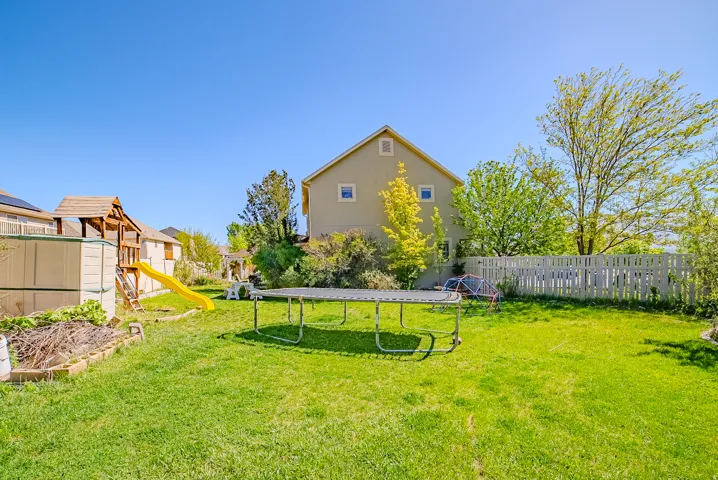Expansive green lawn with a white picket fence enclosing the perimeter