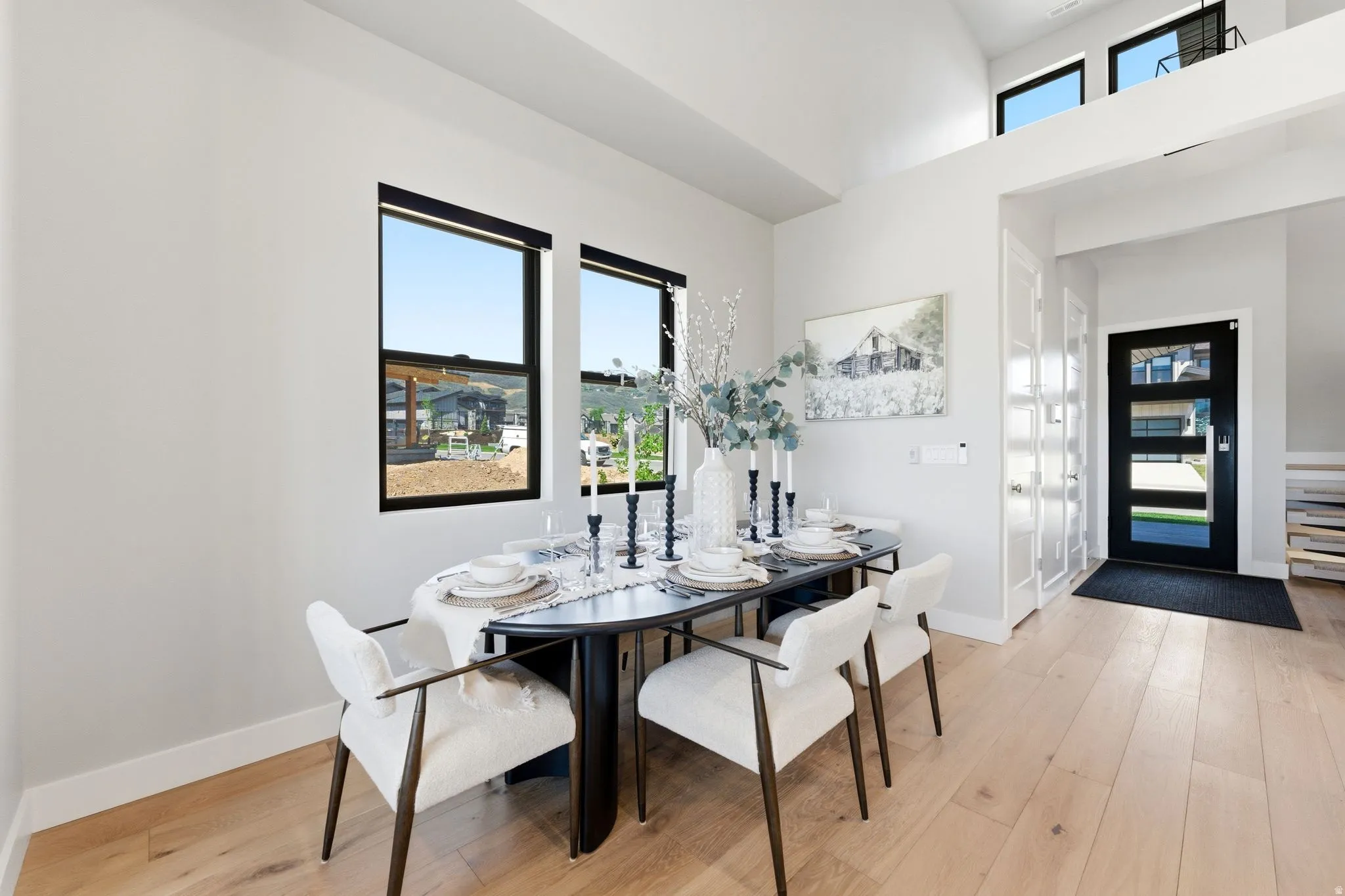 Light wood-finish flooring complements the white walls and high ceilings