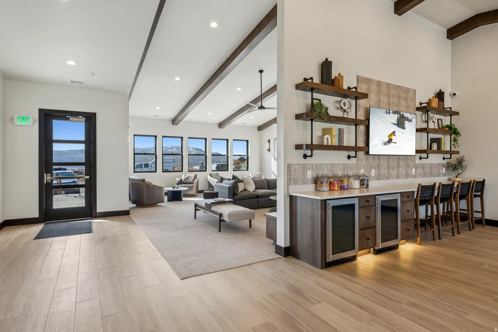 Spacious common area featuring wood-finish flooring, vaulted ceilings with exposed beams, and recessed lighting