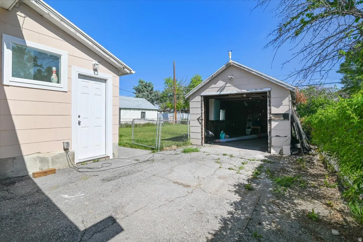 Two detached structures featuring light-colored siding and a concrete driveway