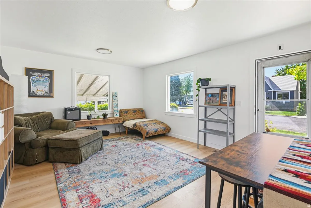 Bright interior space featuring light wood-finish flooring, white walls, multiple windows, and recessed lighting