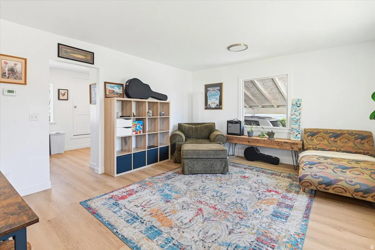 Bright living area featuring light wood-finish flooring and white painted walls